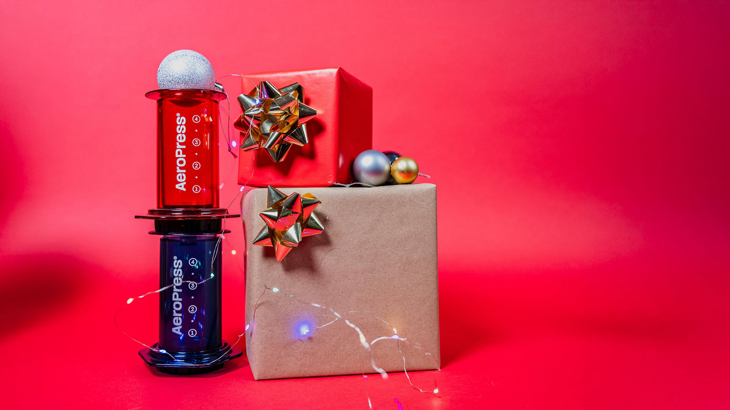 AeroPress Cear Colours Red and Blue beside 2 gift boxes