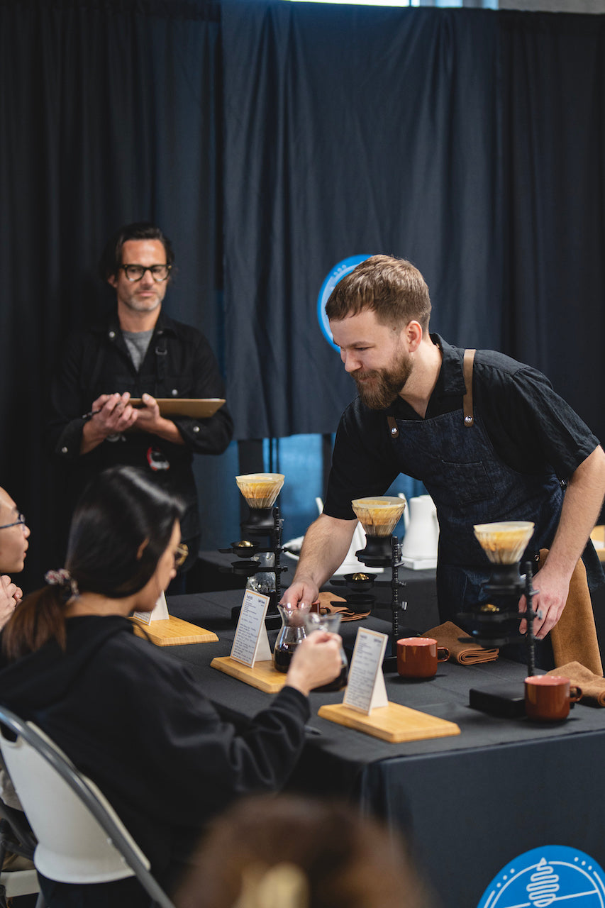 AJ serving coffee to judges using a Paragon Nucleus and Hario Switch for Brewers Cup