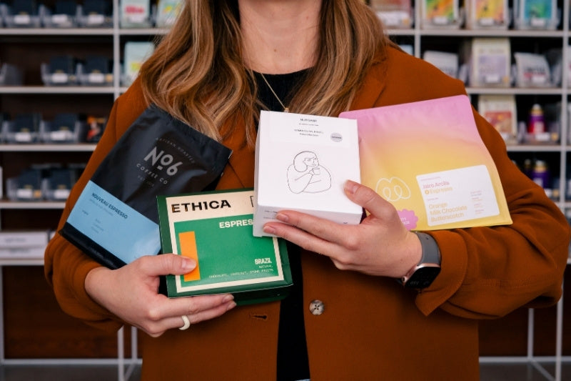 person holding bags of coffee