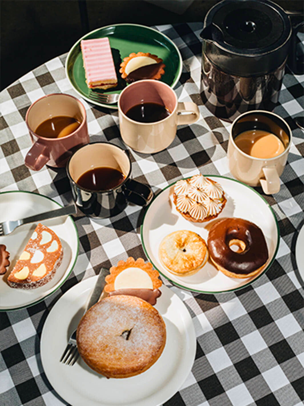 ACME Mugs and Roman plates on a table with desserts. 