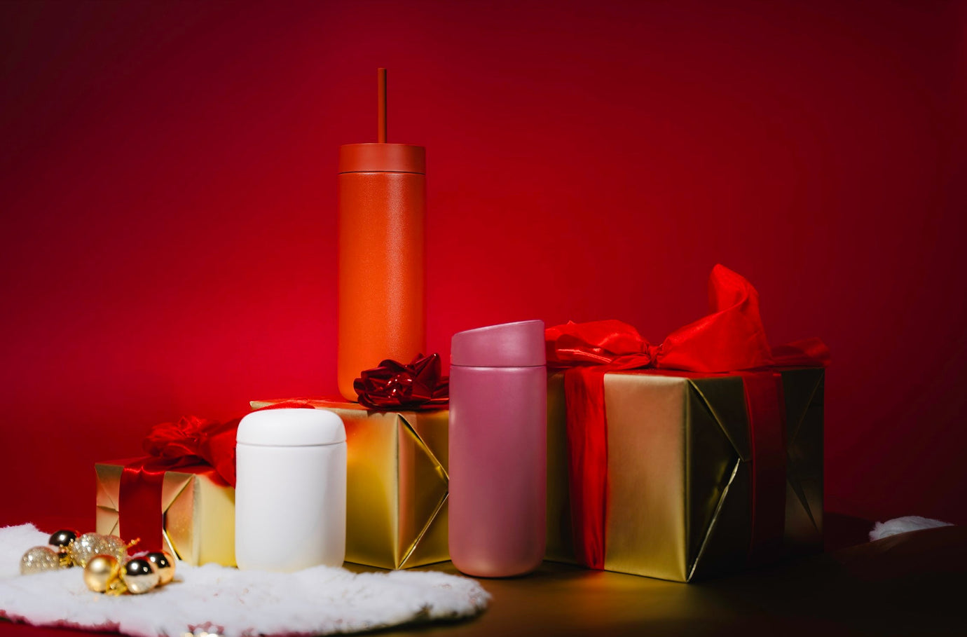 Fellow Carter Move Mugs against red background, surrounded by gold and red Christmas presents