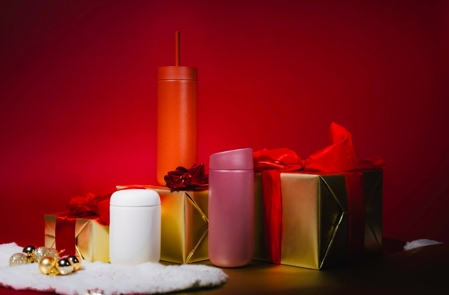 Fellow Carter Move Mugs against red background, surrounded by gold and red Christmas presents
